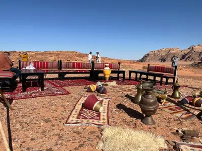 a group of benches in the middle of the desert at Sand Desert Camp in Wadi Rum