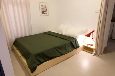 a bedroom with a bed with a green blanket at Sunny Studio in Amman in Amman