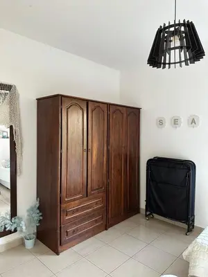 a room with a wooden cabinet and a black tv at Two Bed rooms apartment in Talabay Aqaba Jordan in Aqaba