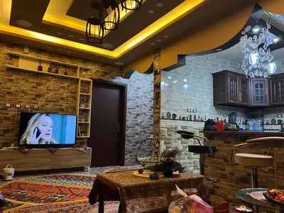 a living room with a tv and a brick wall at Petra Hospitality in Wadi Musa