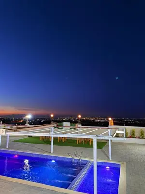 a pool on the roof of a building at night at Milano villa & farm in Balīlā