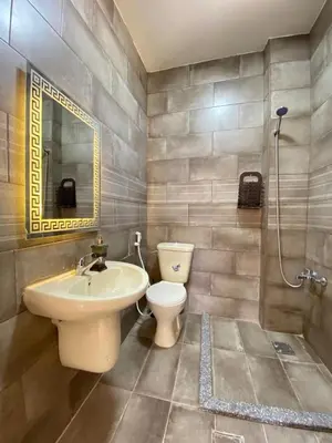 a bathroom with a sink and a toilet and a mirror at panorama tal elroman chalet in Tal‘at ar Ruzz