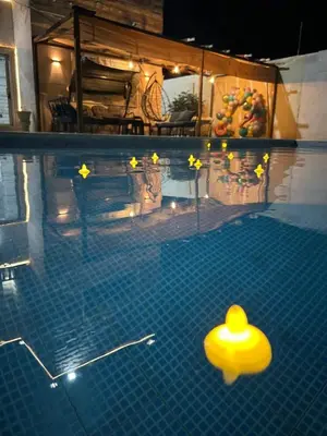a swimming pool with a yellow hat in the water at Entire Home Near Deadsea & Baptism Site Pool, Garden, BBQ, Great Price in Shūnat Nimrīn