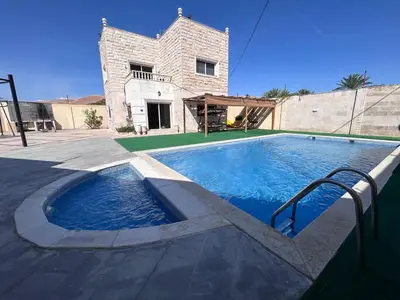 a large swimming pool in front of a house at Entire Home Near Deadsea & Baptism Site Pool, Garden, BBQ, Great Price in Shūnat Nimrīn
