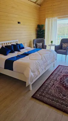 a bedroom with a large bed and a rug at Akwakh Alkhair in Ajloun