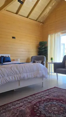 a bedroom with a bed and two chairs and a rug at Akwakh Alkhair in Ajloun