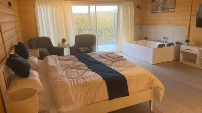 a bedroom with a large bed and a bath tub at Akwakh Alkhair in Ajloun