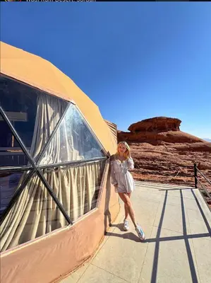 a woman walking down a walkway in the desert at RUM lUXURY SAMA CAMP in Wadi Rum
