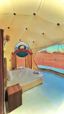 a bedroom with a bed in a tent at WADI RUM EUROPE lUXURY CAMP in Wadi Rum