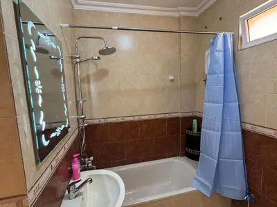 a bathroom with a tub and a sink and a mirror at Casa de petra in Wadi Musa