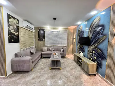 a living room with a couch and a tv at مزرعة وشاليه ادم