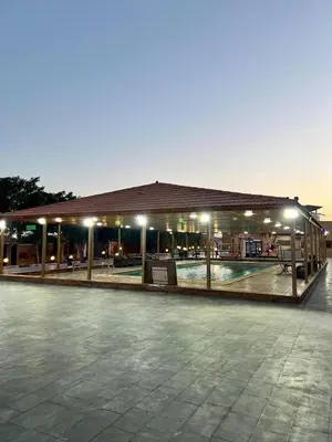 a building with a pool in a parking lot at night at مزرعة وشاليه ادم