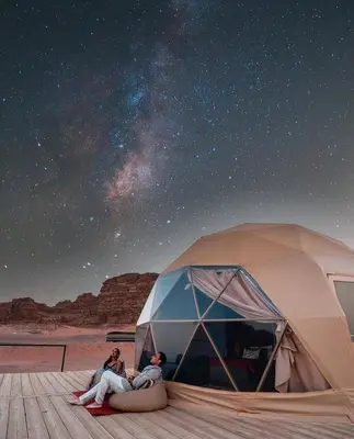 two people sitting in a tent under the stars at RUM Bubble lUXURY CAMP in Disah