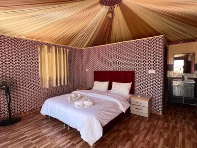 a bedroom with a bed with two cats on it at Suleman Camp in Wadi Rum
