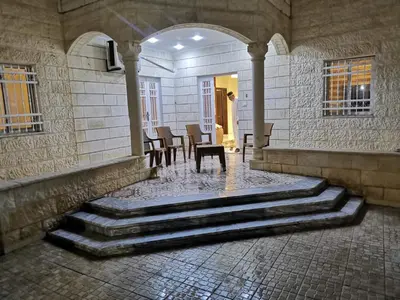 a room with stairs and a table and chairs at دار عدنان للشقق الفندقية المفروشة in Al Mafraq