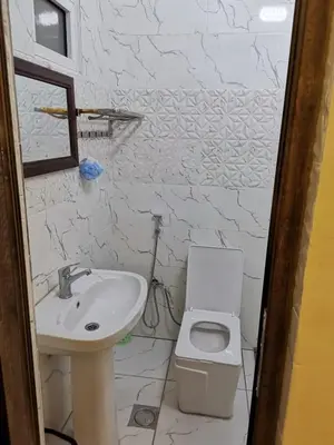 a white bathroom with a sink and a toilet at دار عدنان للشقق الفندقية المفروشة in Al Mafraq