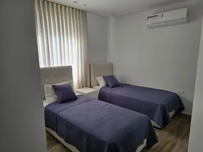a room with two beds with blue sheets and a window at Villa rooftop with stunning view apartment in Amman