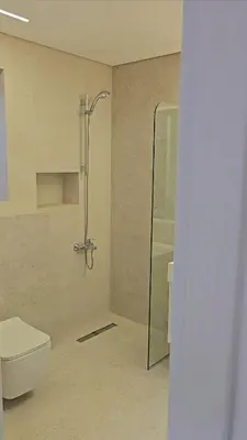 a bathroom with a toilet and a glass shower at Villa rooftop with stunning view apartment in Amman