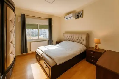 a bedroom with a bed and a dresser and a television at The Central Family Apartment in Amman