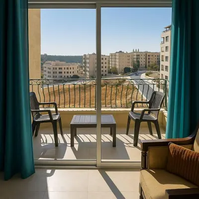a balcony with two chairs and a table on a balcony at The Central Family Apartment in Amman