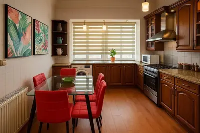 a kitchen with a table and red chairs in it at The Central Family Apartment in Amman