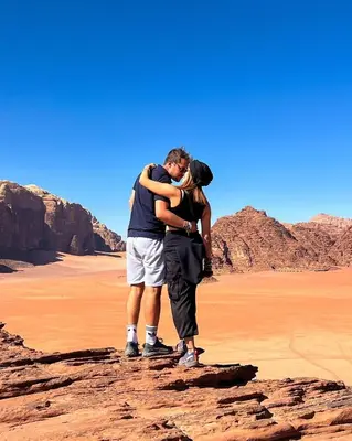 two people standing on a rock in the desert at Camp in the natural reserve & tours in Aqaba