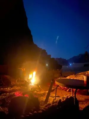 a bonfire on a beach at night at Sahara Camp Wadi Rum in Wadi Rum