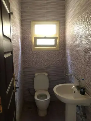 a bathroom with a toilet and a sink at Camera inn in Bushrá