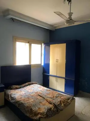 a bedroom with a bed and a blue wall at Camera inn in Bushrá