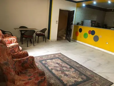 a living room with a couch and a table with chairs at Camera inn in Bushrá
