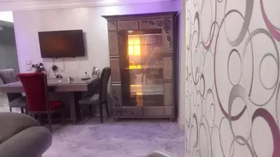 a dining room with a table and a television at Yes inn in Bushrá