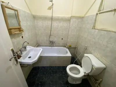 a bathroom with a toilet and a sink and a tub at Yes inn in Bushrá