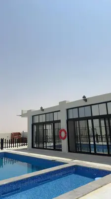a large building with a swimming pool in front of it at Olive tree chalet and farm -مزرعه و شاليه شجره الزيتون