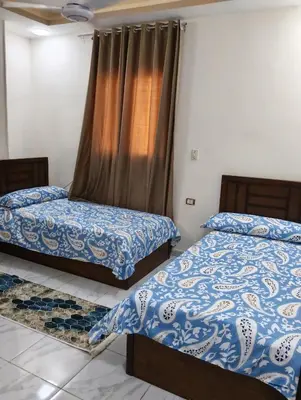 a bedroom with two beds and a window at Tamri guest house in Amman