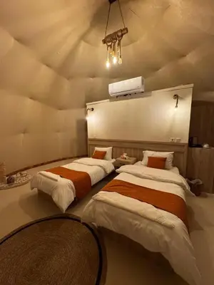 two beds in a room with a ceiling at Dania Luxury Camp in Wadi Rum