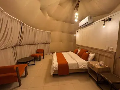 a bedroom with a bed and a tv on the wall at Dania Luxury Camp in Wadi Rum