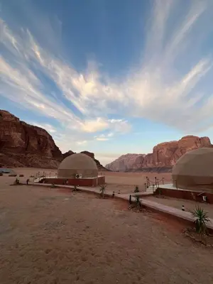 a desert with two domes in a desert with mountains at Dania Luxury Camp in Wadi Rum