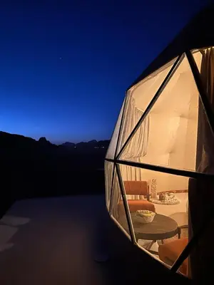 a glass dome with a table and chairs in it at Wadi rum Jad luxury camp in Wadi Rum