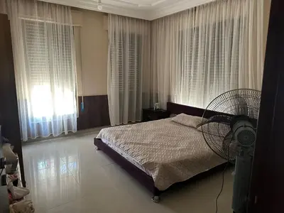 a bedroom with a bed with a fan and windows at Luxurious 5 bedroom Furnished Villa superb locationفيلا فخمه in Amman