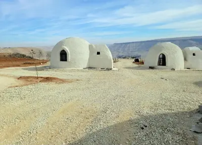 a group of white domed buildings in the desert at Tootya camp