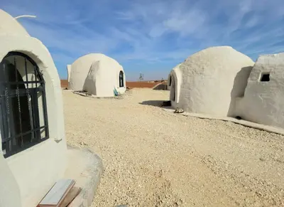 a group of domed buildings in the desert at Tootya camp