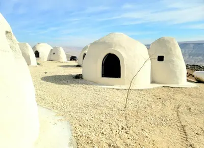 a row of white domes in the desert at Tootya camp