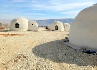 a group of white domed buildings in a desert at Tootya camp