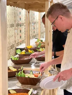 a couple of people preparing food in a buffet at Wadi rum Bubble Bianca luxury in Wadi Rum