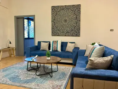 a living room with a blue couch and a table at Spacious central apartment in Amman