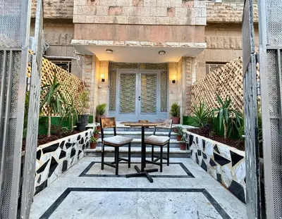 a patio with a table and chairs in front of a building at Spacious central apartment in Amman