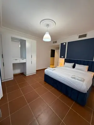 a bedroom with a large bed with a blue headboard at 3bedroom aprt of 200sqm near movenpick hotel amman in Amman