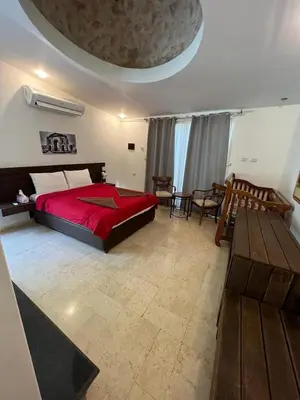 a bedroom with a red bed and a table at Sossita Guesthouse & Boutique Resort
