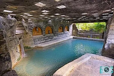 a large pool of water in a stone building at Sossita Guesthouse & Boutique Resort