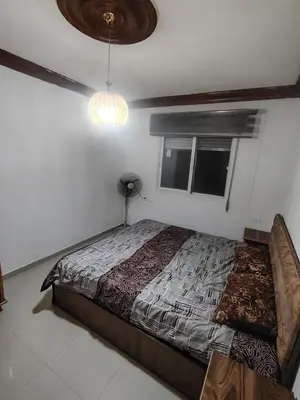 a bedroom with a bed and a window at الشهم 10 in Irbid